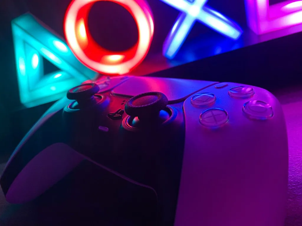 DualSense controller under neon PlayStation lights